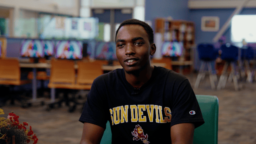 Camelback High School student Pierre wearing an ASU Sun Devils T-shirt in a school media center.